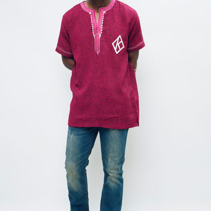 Person wearing a maroon embroidered shirt and blue jeans on a white background.The product is Kappa Alpha Psi African Wear, specifically designed for members of the prestigious African American fraternity. This apparel is a symbol of pride and unity among the members of the organization, showcasing their heritage and cultural background. With the iconic symbols and colors of Kappa Alpha Psi, this African wear is a must-have for any member looking to represent their fraternity in a stylish and meaningful way