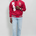 Red varsity jacket with white lettering and light blue jeans on a plain background.Check out our Kappa Alpha Psi satin jacket selection for the very best in unique design. This Kappa Alpha Psi Baseball Nylon Jacket shows the fraternity Shield embroidered on left chest and Greek letters on right to create style and unique comfort in wear. Quality beyond imagination.
