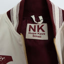 Close-up of a jacket with a 'Nupe Kave' label on a plain background.The Kappa Alpha Psi Cream Twill Jacket is a stylish and classic outerwear option for men. Made with durable twill material, this jacket features the signature ivory/ cream color of the Nupe Kave brand. It is designed with regular sizing in mind, making it a versatile option for a variety of men's sizes. Perfect for adding a touch of sophistication to any outfit, this jacket is a must-have for any man looking to showcase.