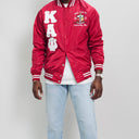 Red varsity jacket with white lettering and design on a plain background.Check out our Kappa Alpha Psi satin jacket selection for the very best in unique design. This Kappa Alpha Psi Baseball Nylon Jacket shows the fraternity Shield embroidered on left chest and Greek letters on right to create style and unique comfort in wear. Quality beyond imagination.
