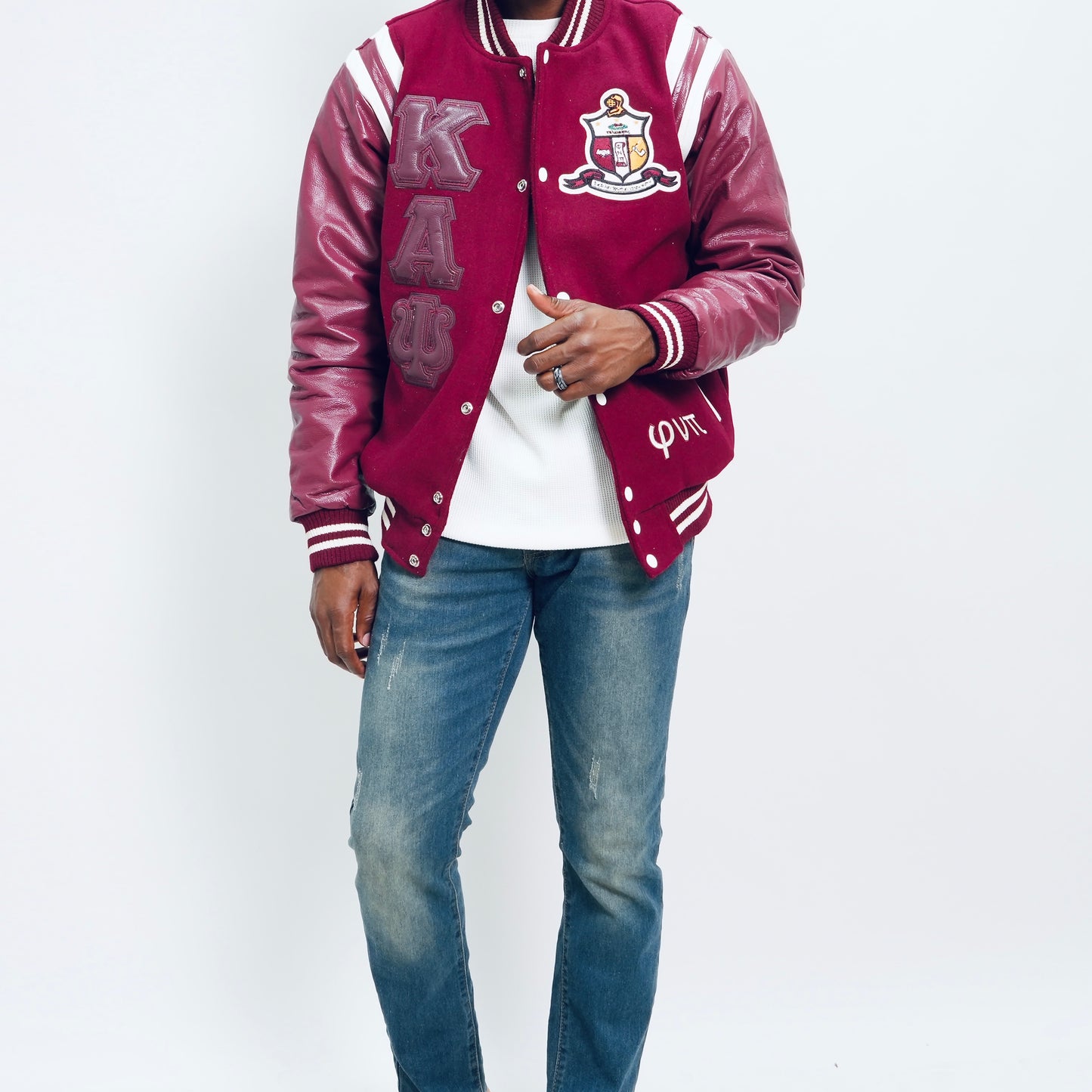 Person wearing a maroon varsity jacket with white lettering on a white background.The Kappa Alpha Psi Letterman Varsity Jacket is a collectible item that showcases the history and symbolism of the fraternity organization. Made with durable materials, this jacket is designed to last and serve as a tangible reminder of the values and traditions upheld by members of Kappa Alpha Psi. Perfect for Nupe looking to show their pride and affiliation with the organization, this jacket is a piece of fraternal.