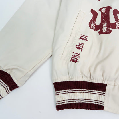 Close-up of a cream-colored varsity jacket with red lettering on a white background.The Kappa Alpha Psi Cream Twill Jacket is a stylish and classic outerwear option for men. Made with durable twill material, this jacket features the signature ivory/ cream color of the Nupe Kave brand. It is designed with regular sizing in mind, making it a versatile option for a variety of men's sizes. Perfect for adding a touch of sophistication to any outfit, this jacket is a must-have for any man looking to showcase.