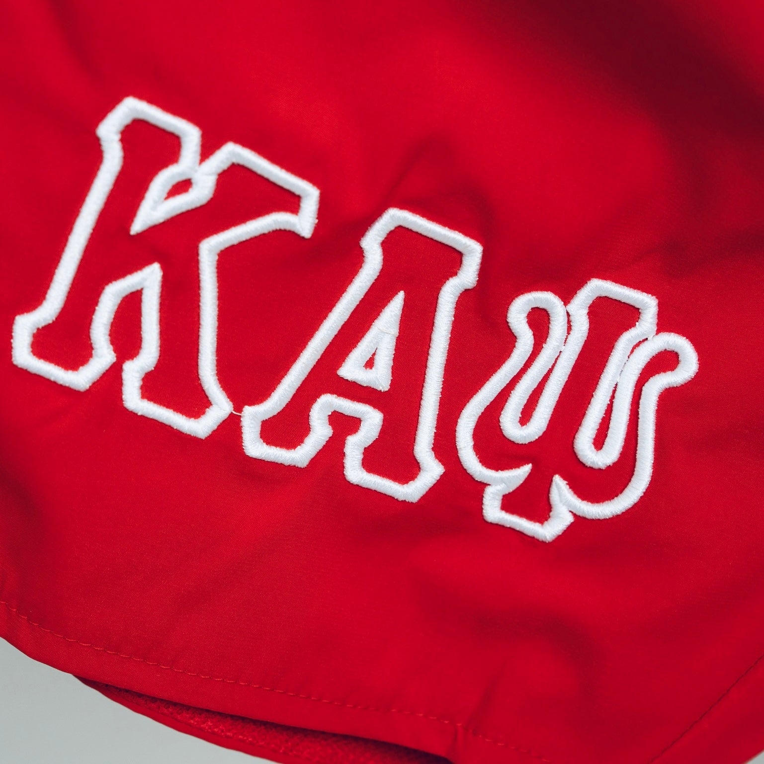 The Kappa Alpha Psi “Phi Nu Pi” Red And White Shorts are a collectible item that represents the historical significance of Kappa Alpha Psi Fraternity Inc. These shorts are a symbol of pride and unity among members in Phi Nu Pi, showcasing their commitment to the principles of the Kappa Alpha Psi Fraternity. Made in red and white, these shorts are a unique piece of memorabilia that serves as a reminder of the bond shared among brothers and membersRed shorts with white embroidered letters on a gray background