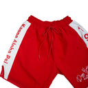 Red shorts with white side panels featuring text on a light gray background.The Kappa Alpha Psi red Summer Short is a collectible item that represents the historical memorabilia of Kappa Alpha Psi Fraternity Inc . It is a symbol of pride and heritage for members of the Kappa Alpha Psi Fraternity, showcasing their commitment to their values and traditions from 1911. This short is a tangible piece of history that serves as a reminder of the legacy and contributions of the organization.