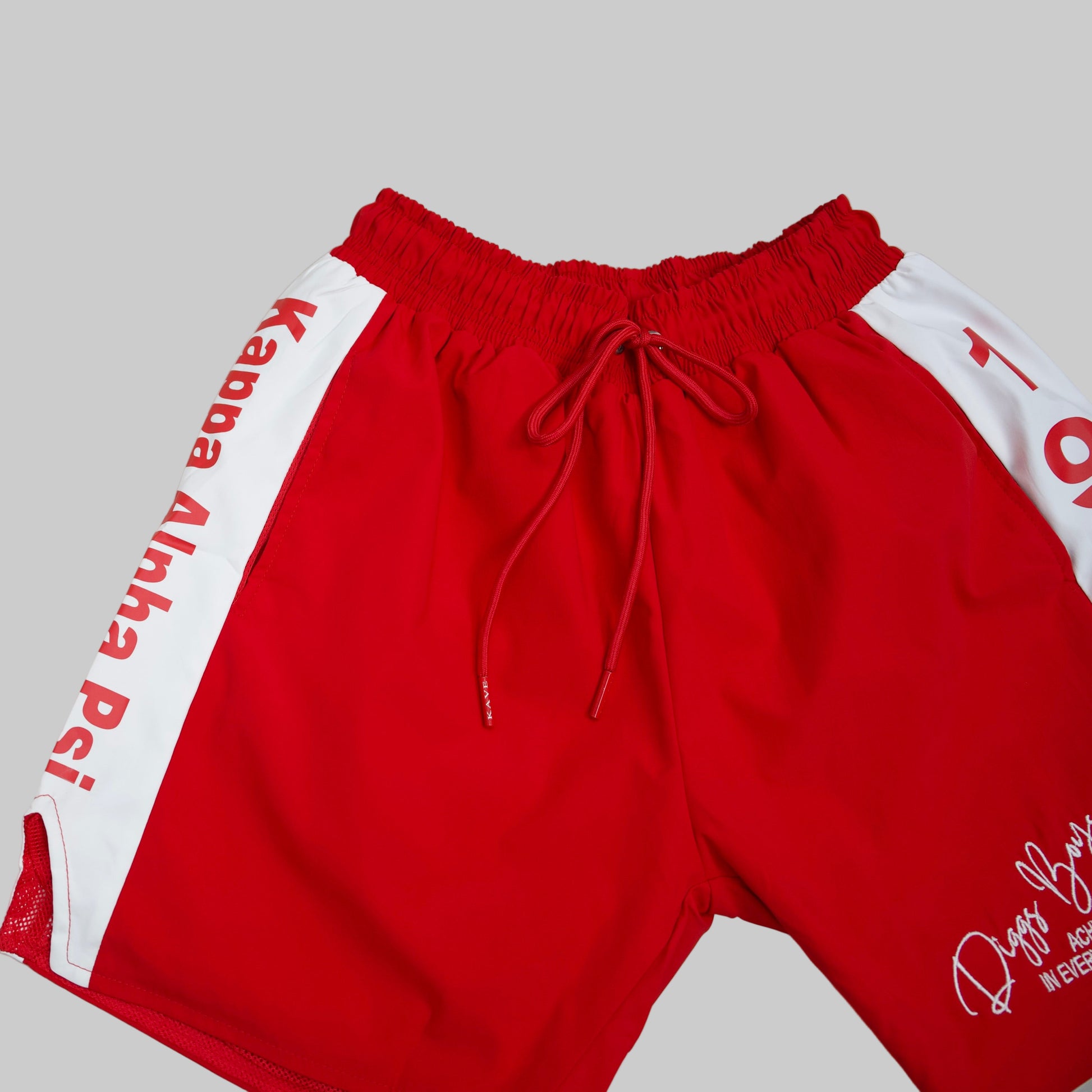 Red shorts with white side panels featuring text on a light gray background.The Kappa Alpha Psi red Summer Short is a collectible item that represents the historical memorabilia of Kappa Alpha Psi Fraternity Inc . It is a symbol of pride and heritage for members of the Kappa Alpha Psi Fraternity, showcasing their commitment to their values and traditions from 1911. This short is a tangible piece of history that serves as a reminder of the legacy and contributions of the organization.