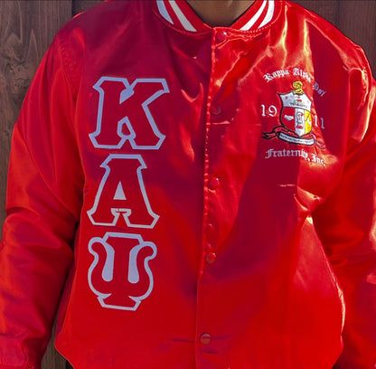 Check out our Kappa Alpha Psi satin jacket selection for the very best in unique design. This Kappa Alpha Psi Baseball Satin Jacket shows the fraternity Shield embroidered on left chest and Greek letters on right to create style and unique comfort in wear. Quality beyond imagination.